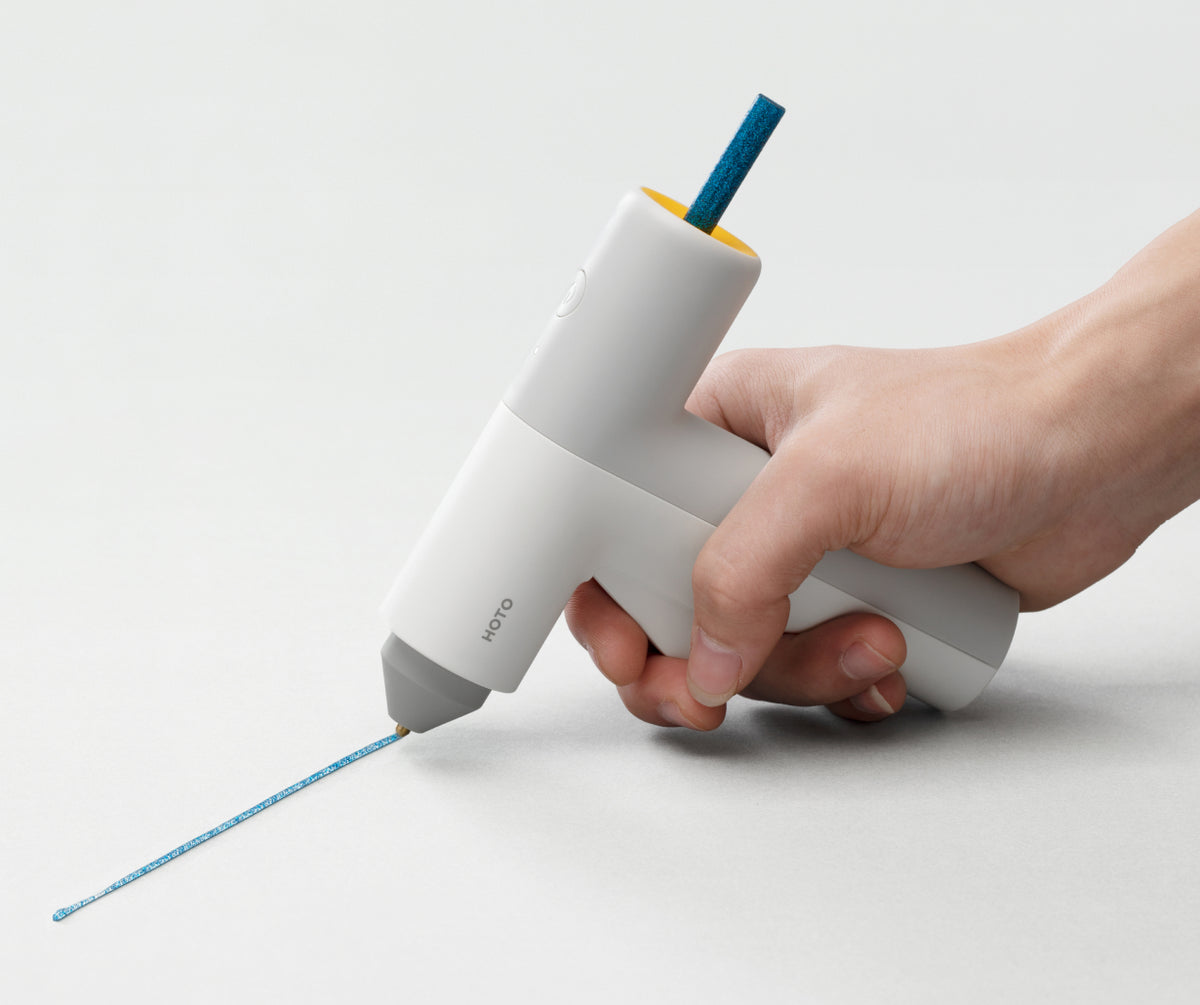 HOTO glue gun applying a narrow controlled line of hot melt adhesive