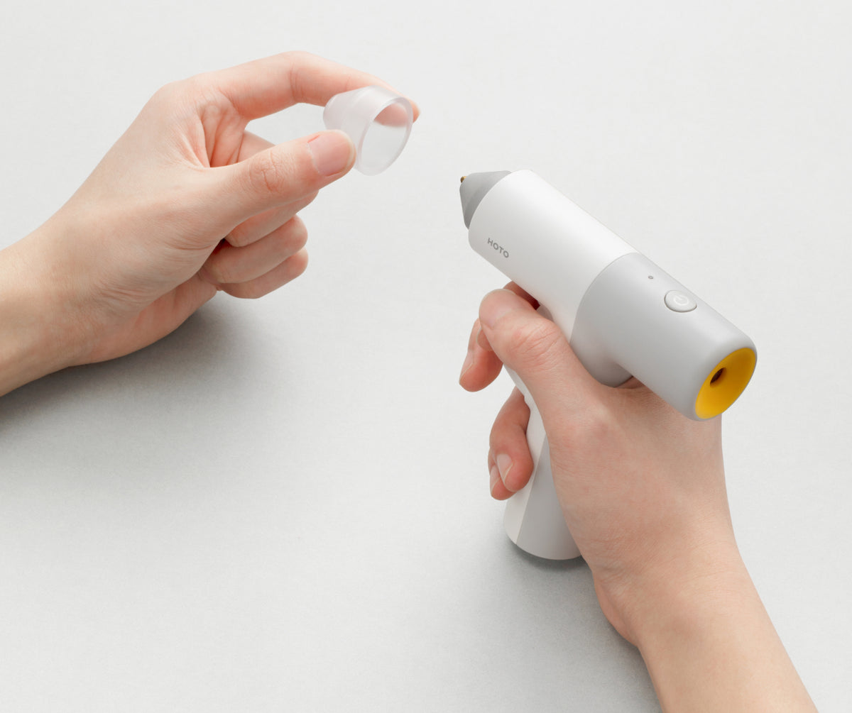 Heat-resistant protective cap being placed on HOTO glue gun