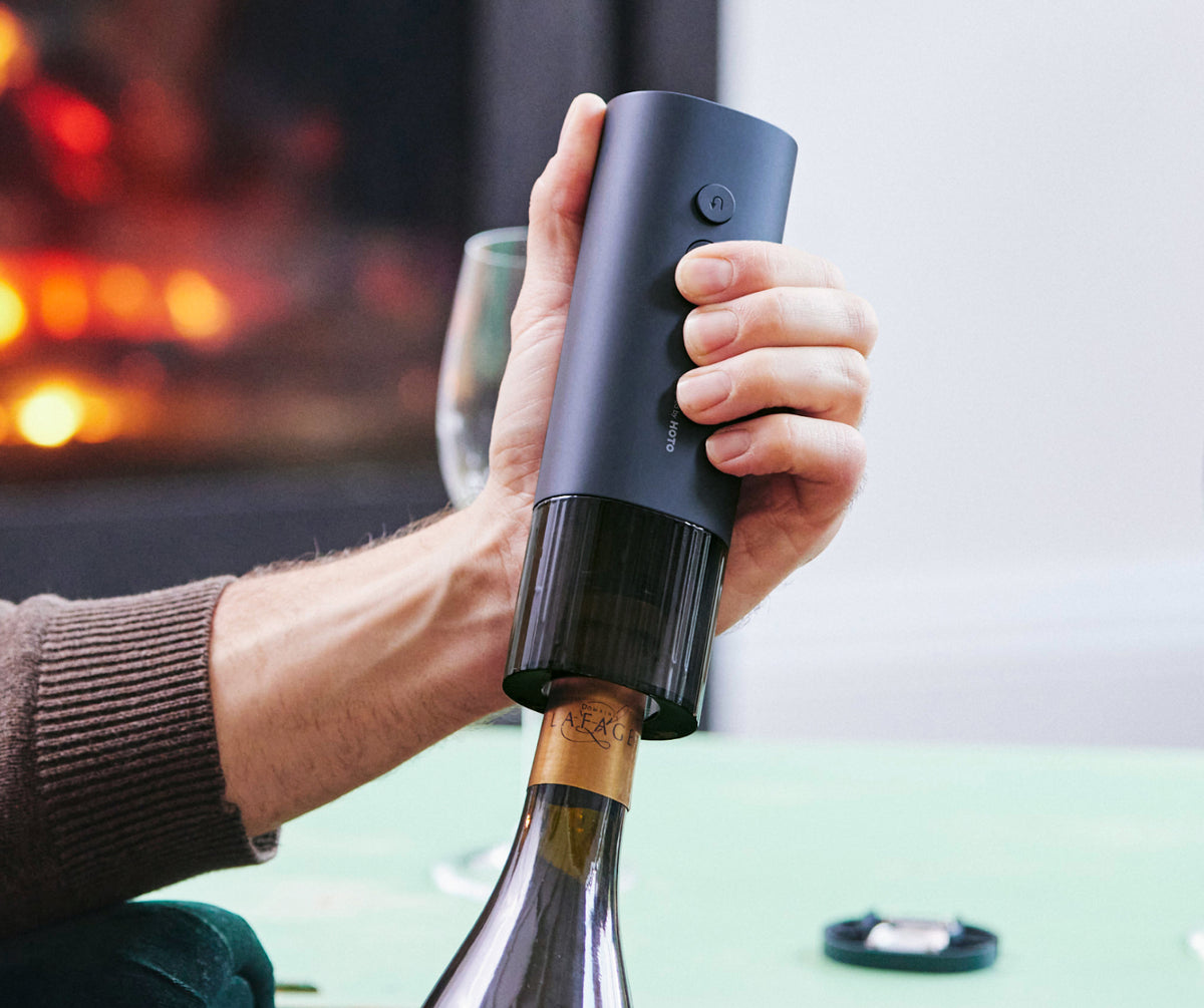 HOTO Electric Wine Opener held vertically over a corked wine bottle