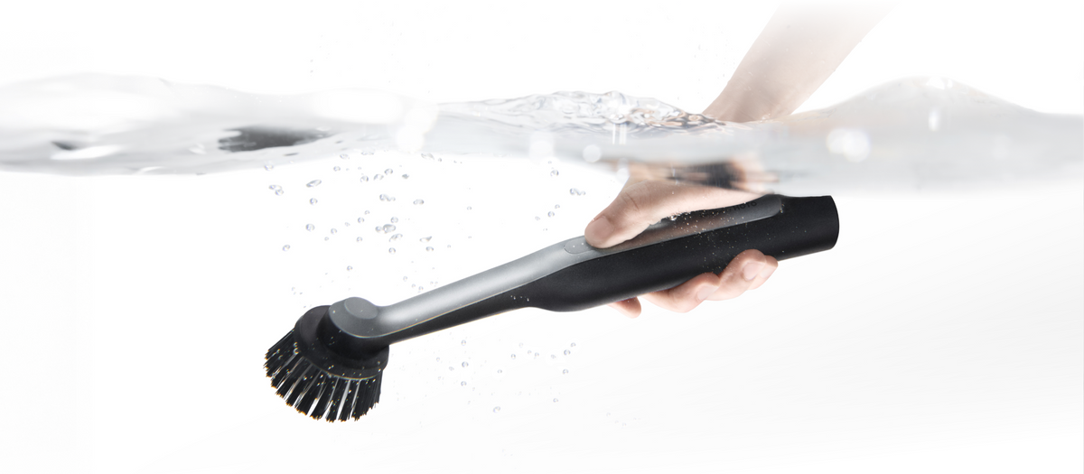 HOTO Wand IPX7 waterproof cordless scrubber being rinsed under water